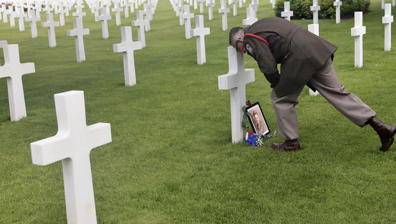 World War II history enthusiast Arnauld Villalard marks respect on a headstone in the U.S. cemetery of Colleville-sur-Mer, Normandy, Saturday, June, 4 2022. Several ceremonies will take place to commemorate the 78th anniversary of D-Day that led to the liberation of France and Europe from the German occupation.