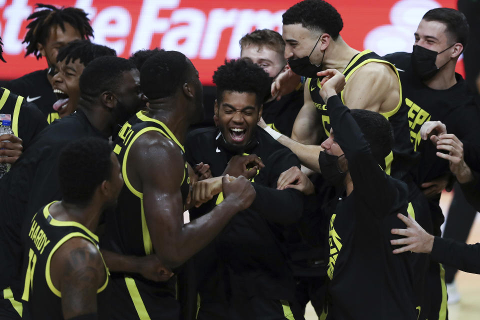 Oregon's Aaron Estrada, center, and teammates celebrate their team's win over Oregon State and their second consecutive Pac-12 regular-season conference title following an NCAA college basketball game in Corvallis, Ore., Sunday, March 7, 2021. (AP Photo/Amanda Loman)