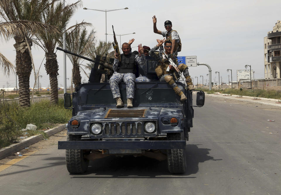 Iraqi security forces celebrate as they drive on the main road between Baghdad and Tikrit, 80 miles north of Baghdad, Iraq, Friday, April 3, 2015. (AP Photo/Khalid Mohammed)