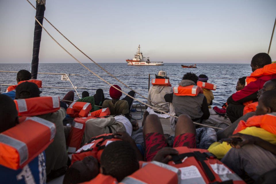 Migrants rest on a Mediterranea Saving Humans NGO boat, as they sail off Italy's southernmost island of Lampedusa, just outside Italian territorial waters, on Thursday, July 4, 2019. An Italian humanitarian group whose boat has been barred from docking in Lampedusa said the health of the 54 migrants it rescued at sea is rapidly deteriorating, prompting fears of another standoff with Italy's populist government. Mediterranea Saving Humans said Friday in a tweet that its sailing boat ALEX was off Italy's southernmost island of Lampedusa, just outside Italian territorial waters, and that it has been banned from entering Italian jurisdiction by ministerial decree. (AP Photo/Olmo Calvo)
