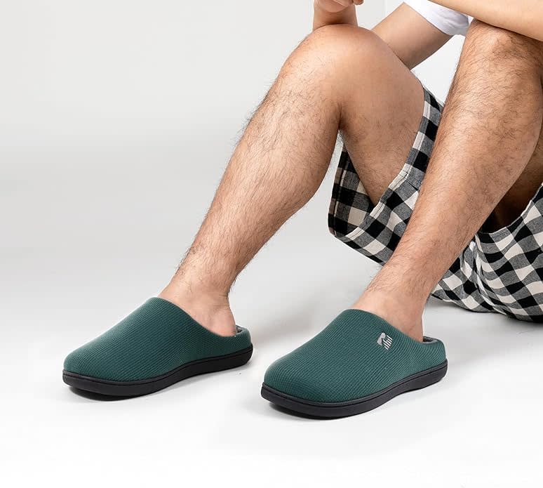 someone is wearing the RockDove Men's Original Two-Tone Memory Foam Slippers from Amazon 