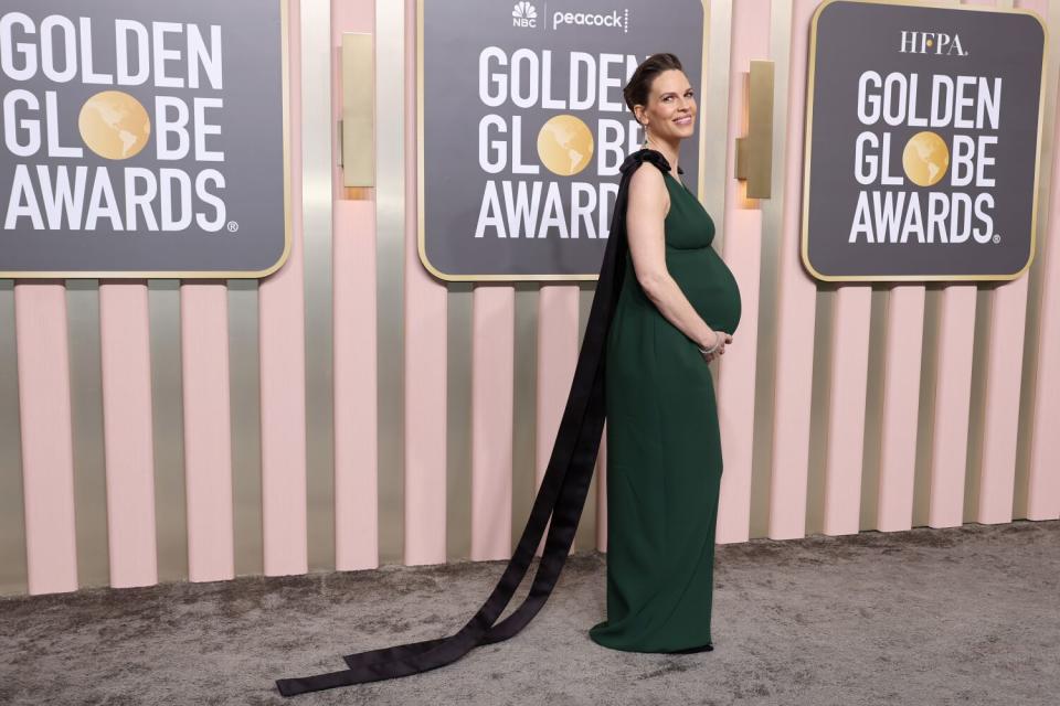 Hilary Swank poses in a Prada gown on the red carpet.