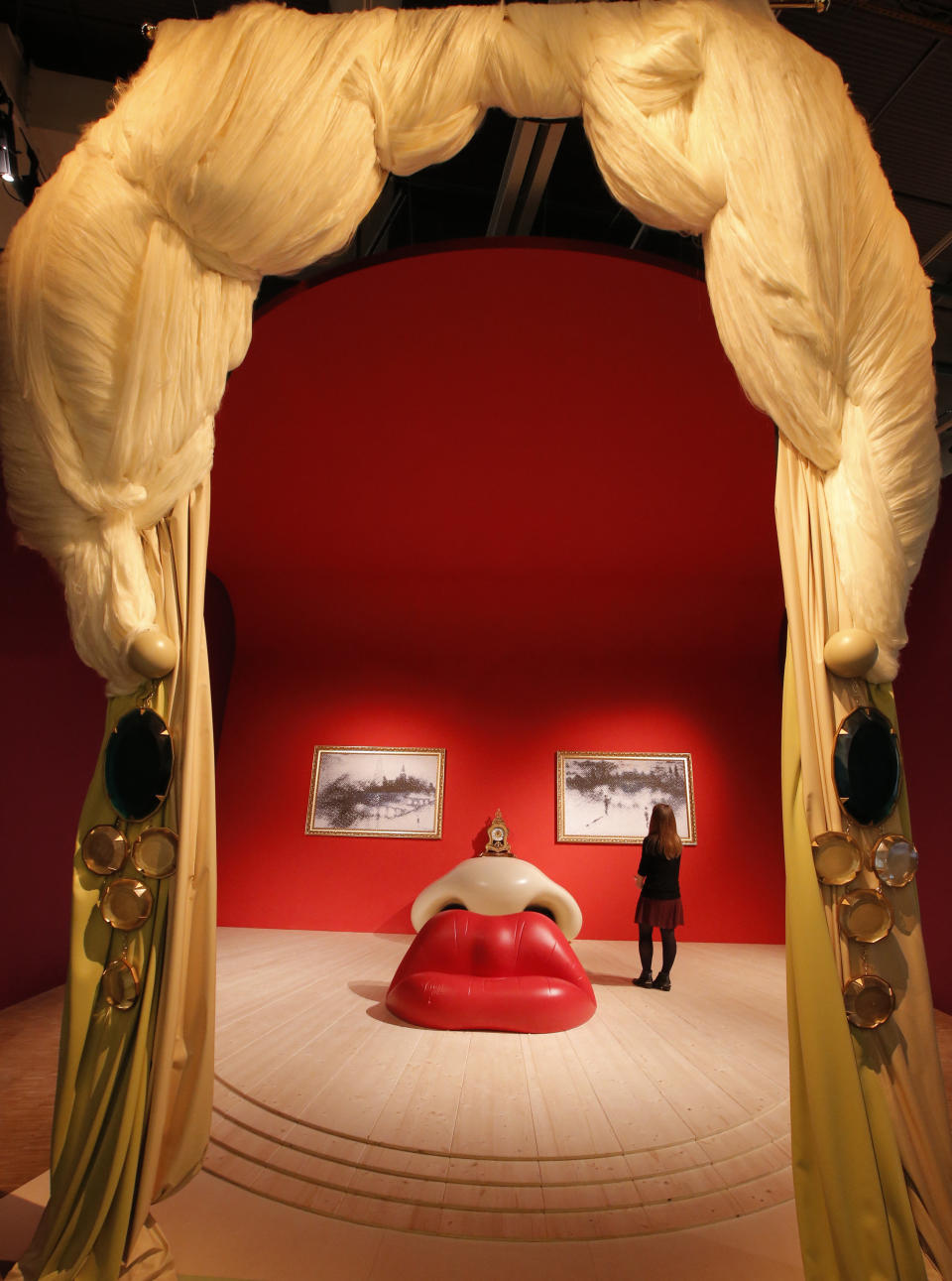 In this photo taken Monday, Nov. 19, 2012, a visitor stands in the 'Mae West, 1934' room by Spanish artist Salvador Dali (1904-1989) during the presentation to the press of the exhibition "Dali" at the Centre Pompidou modern art museum, in Paris. A major retrospective of Salvador Dali in Paris aims to rewrite the art history books, reconciling for the first time the last decades of his life _ when he was accused of money-making self-publicity through numerous television appearances _ with his earlier, respected Surrealist period. (AP Photo/Francois Mori)