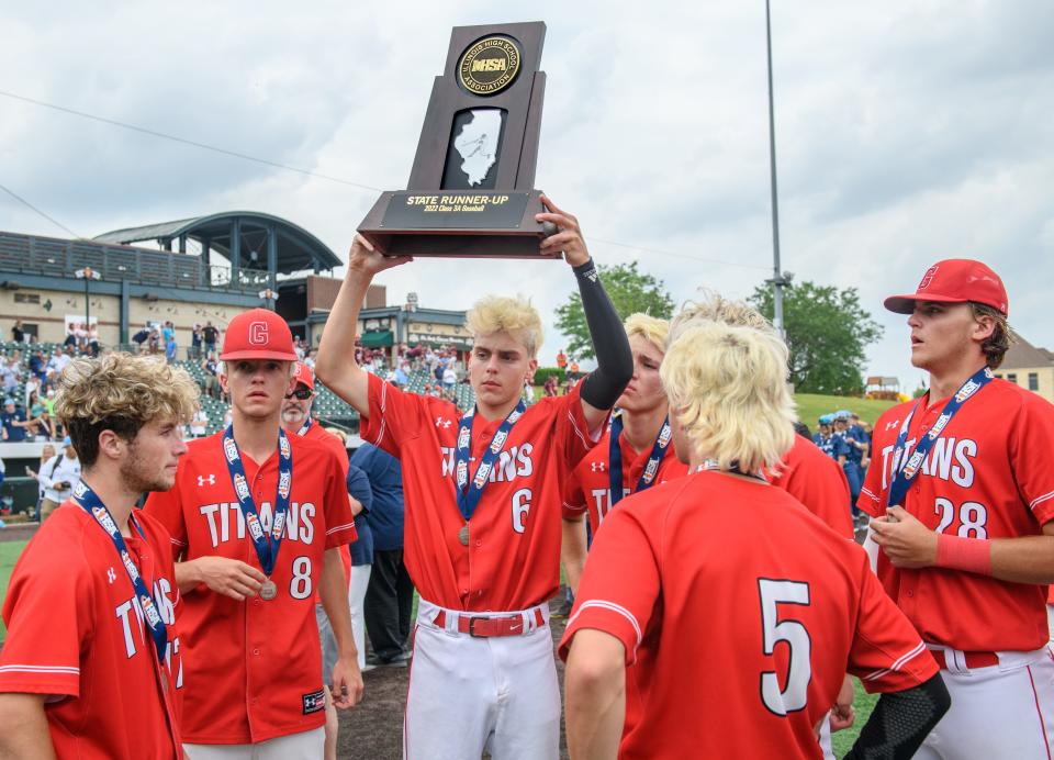 Chatham Glenwood's Eli Curtis lifts the second-place trophy after the Titans' 5-1 loss to Nazareth Academy in the Class 3A state baseball title game Saturday, June 11, 2022 at Duly Health & Care Field in Joliet.