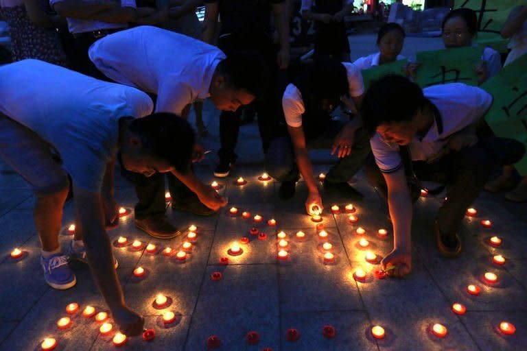 Chines villager pray for the victims of the Gansu earthquake in Loudi, Hunan province, on July 22, 2013. The traumatised survivors of two shallow earthquakes that killed at least 94 people in China have begun burying their dead, as they struggled with the devastation left behind