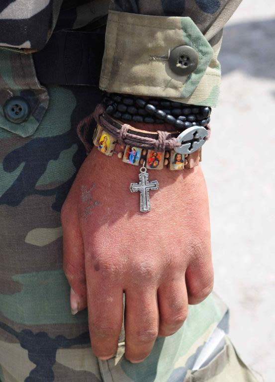 A Syrian soldier wears Christian icons in the ancient Christian town of Maalula, northeast of Damascus, on April 14, 2014 after government forces took control of the town from rebel fighters