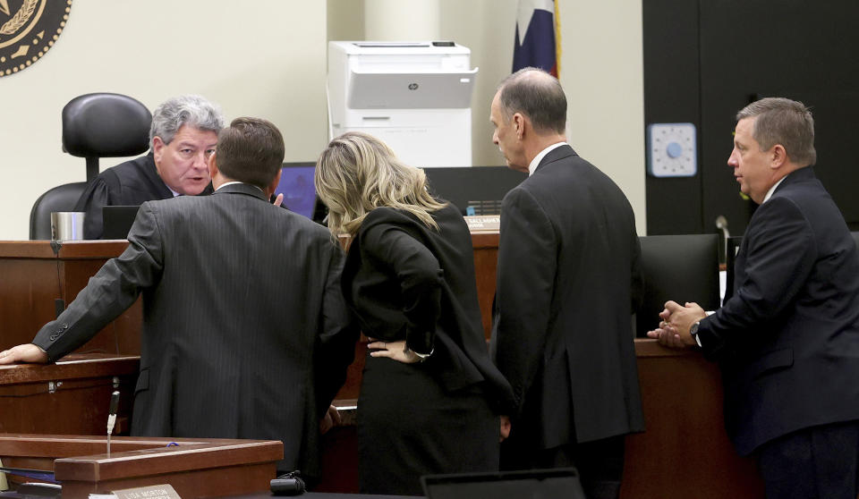 Judge George Gallagher talks to the the state and defense attorneys during the first day of the murder trial of former Fort Worth Police Officer Aaron Dean on Monday, Dec. 5, 2022, in Fort Worth, Texas. From left, Assistant Tarrant County Criminal District Attorney R. Dale Smith, Assistant Criminal District Attorney Ashlea Deener, defense attorney Bob Gill and defense attorney Miles Brissette. Dean fatally shot Atatiana Jefferson, a Black woman, through a window of her own Fort Worth home during a police call in 2019. (Amanda McCoy/Star-Telegram via AP, Pool)