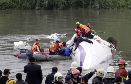 Rescuers pull a passenger out of the TransAsia Airways plane which crash landed in a river, in New Taipei City, February 4, 2015. REUTERS/Pichi Chuang