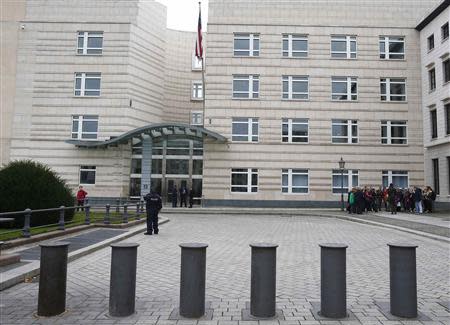 People stand next to entrance of the U.S. Embassy in Berlin October 25, 2013. REUTERS/Tobias Schwarz