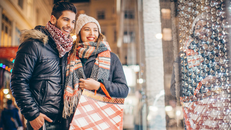 happy couple window shopping on cold winter night