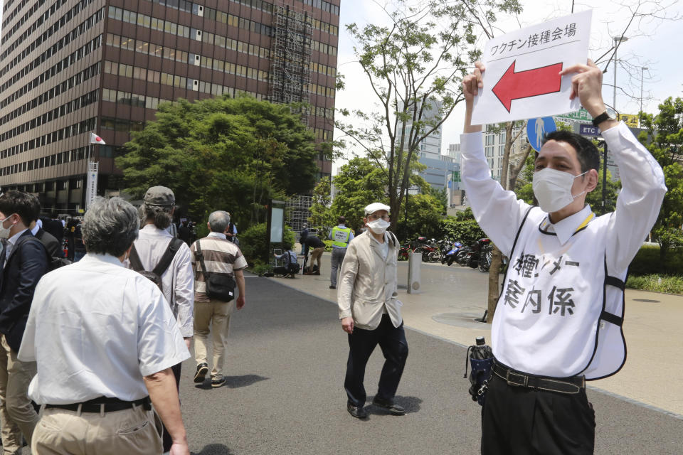 People are guided at a mass vaccination center in Tokyo, Monday, May 24, 2021. Japan mobilized military doctors and nurses to give shots to elderly people in Tokyo and Osaka on Monday as the government desperately tries to accelerate its vaccination rollout and curb coronavirus infections just two months before hosting the Olympics. People inoculated at the centers on Monday were the first in Japan to receive doses from Moderna Inc., one of two foreign-developed vaccines Japan approved on Friday.(AP Photo/Koji Sasahara)