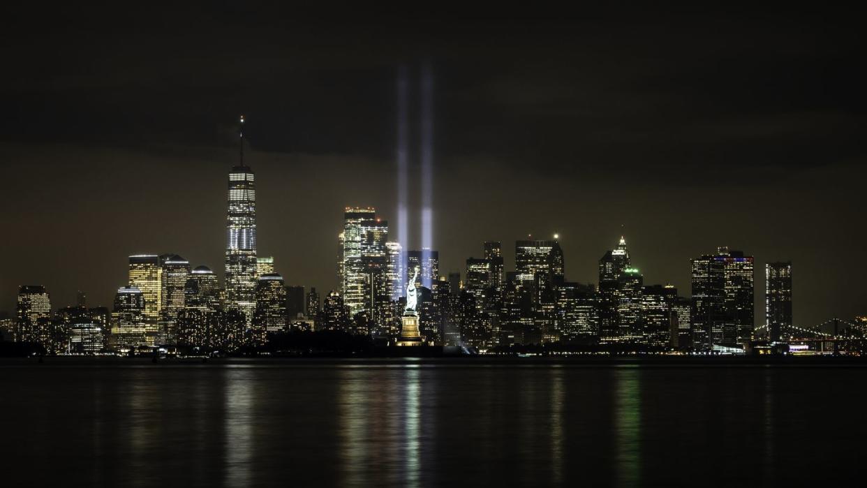 9 11 quotes new york skyline at night with two beams representing the world trade center