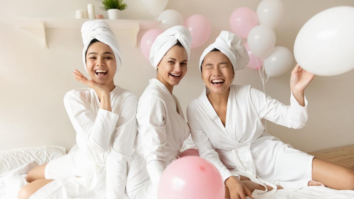 well groomed girls in bathrobes gather together celebrating bridal shower