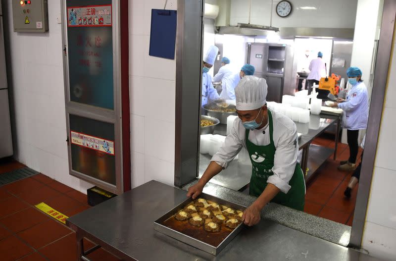 Un cocinero sirve comida de una cocina del Primer Hospital Popular del Distrito de Xiaoshan, Hangzhou, un hospital designado para pacientes con coronavirus nuevos en la provincia de Zhejiang, China, el 14 de febrero de 2020