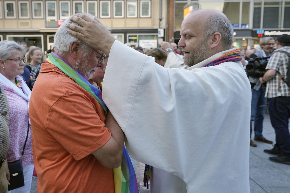 Married and same-sex couples take part in a public blessing ceremony in front of the Cologne Cathedral in Cologne, Germany, Wednesday, Sept. 20, 2023. Several Catholic priests held a ceremony blessing same-sex and also re-married couples outside Cologne Cathedral in a protest against the city's conservative archbishop, Cardinal Rainer Maria Woelki. (AP Photo/Martin Meissner)