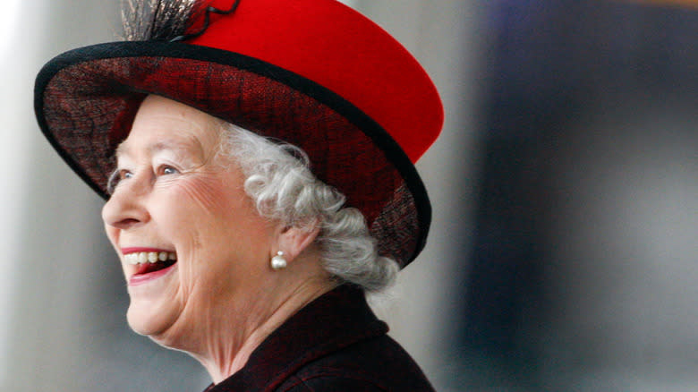 Queen Elizabeth smiling in red hat