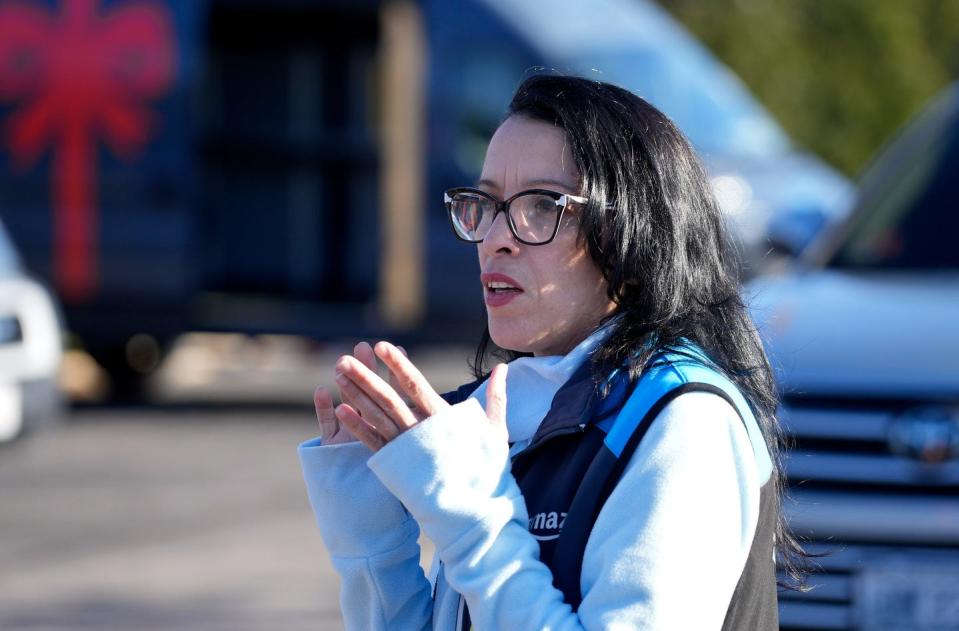 Operations manager Ligia Diaz-Martinez talks to drivers in English and Spanish during a morning meeting before they load their vans at the Amazon warehouse in Providence.