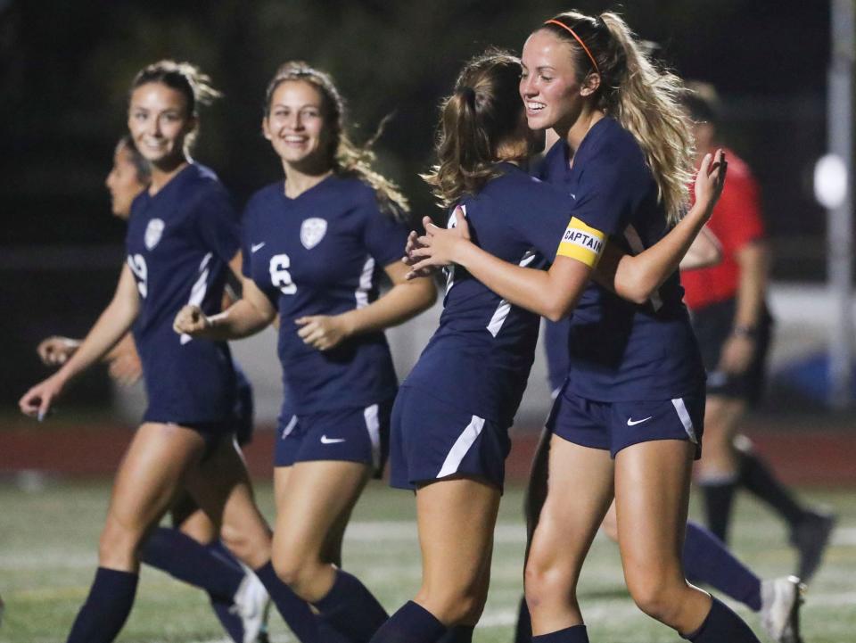 Naples Golden Eagles midfielder Lucy Froitzheim (12) is hugged by midfielder Bridgette Graney (8) after scoring during the second half of a game at Staver Field in Naples on Tuesday, Jan. 17, 2023.