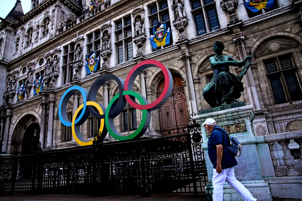 A man walks past the Olympic rings in front of the Paris City Hall (Getty Images)