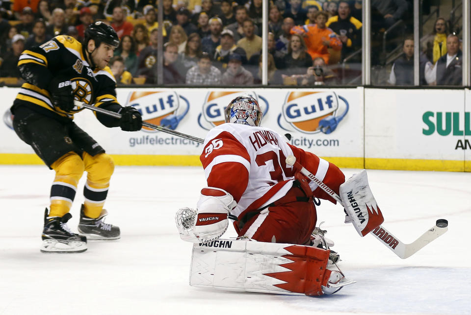 Boston Bruins' Milan Lucic, left, scores on Detroit Red Wings goalie Jimmy Howard during the second period of Game 2 of a first-round NHL hockey playoff series in Boston Sunday, April 20, 2014. (AP Photo/Winslow Townson)