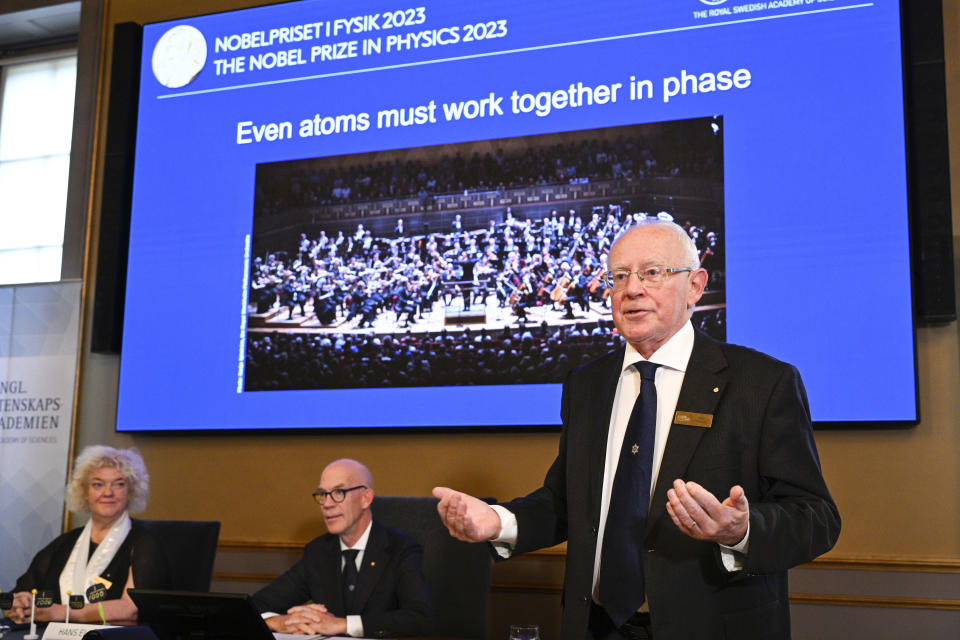 Mats Larsson, right, member of the Royal Academy of Sciences, speaks during the announcement of the winner of the 2023 Nobel Prize in Physics, at the Royal Academy of Sciences, in Stockholm, Tuesday, Oct. 3, 2023. The Nobel Prize in physics has been awarded to Pierre Agostini, Ferenc Krausz and Anne L’Huillier for looking at electrons in atoms by the tiniest of split seconds. (Anders Wiklund/TT News Agency via AP)