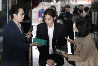 K-pop singer Jung Joon-young is questioned by reporters upon his arrival to attend a hearing at the Seoul Central District Court in Seoul, South Korea, Thursday, March 21, 2019. A South Korean pop star has appeared at a court hearing to decide whether to arrest him over allegations that he illegally shared sexually explicit videos of women taken without their knowledge or consent in online group chats. (AP Photo/Lee Jin-man)