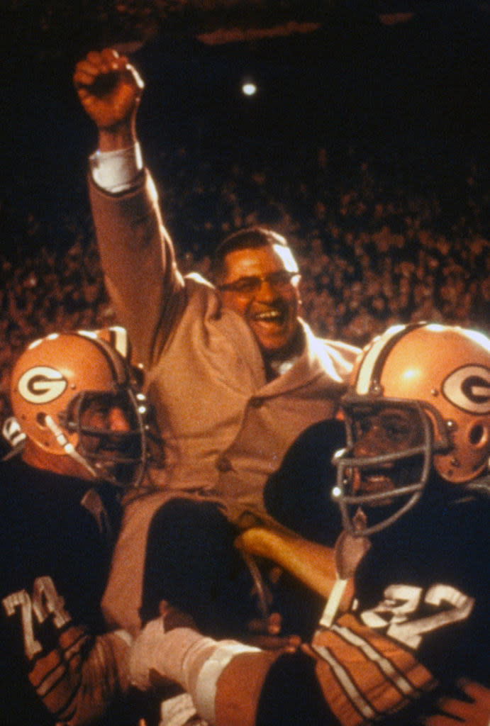 players lifting up a coach to celebrate