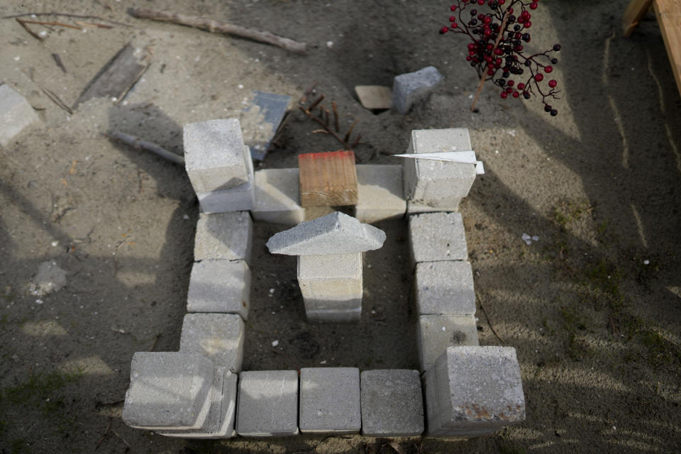 A castle constructed by children and made from concrete blocks is in a makeshift garden at the Ukraine village, which has been constructed for Ukrainian families fleeing the war, in Linkeroever, Belgium, Friday, March 17, 2023. Despite the warm welcome for millions of Ukraine refugees on European Union soil since the Russian invasion, EU officials said Tuesday, June 6, 2023 that there are some fears of wavering support caused by a bad economy hitting poor families especially and the creeping influence of Russian propaganda. (AP Photo/Virginia Mayo)