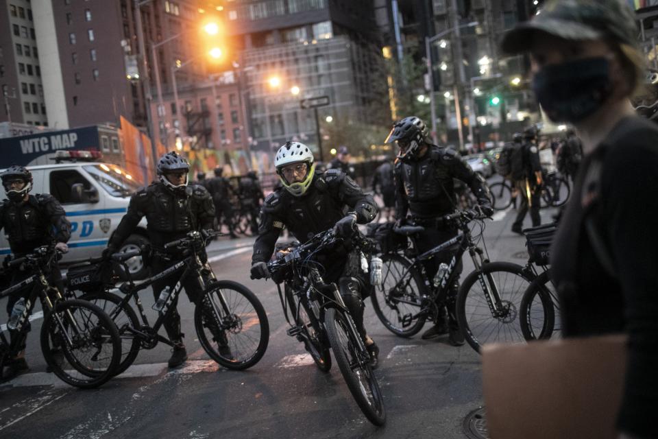 Police cycle in to arrest protesters refusing to get off the streets during an imposed curfew while marching in a solidarity rally calling for justice over the death of George Floyd, Tuesday, June 2, 2020, in New York. Floyd died after being restrained by Minneapolis police officers on May 25. (AP Photo/Wong Maye-E)