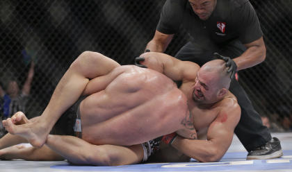 The referee stops the fight as Glover Teixeira, right, locks James Te Huna into a submission. (AP)