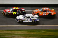 DAYTONA BEACH, FL - FEBRUARY 27: Jeff Gordon, driver of the #24 Drive to End Hunger Chevrolet, Mark Martin, driver of the #55 Aaron's Toyota, and Joey Logano, driver of the #20 The Home Depot Toyota, race during the NASCAR Sprint Cup Series Daytona 500 at Daytona International Speedway on February 27, 2012 in Daytona Beach, Florida. (Photo by Streeter Lecka/Getty Images)