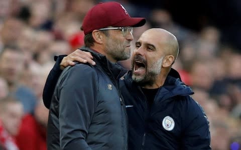 Jurgen Klopp smiles as Pep Guardiola wraps his arm around the Liverpool manager - Credit: REUTERS