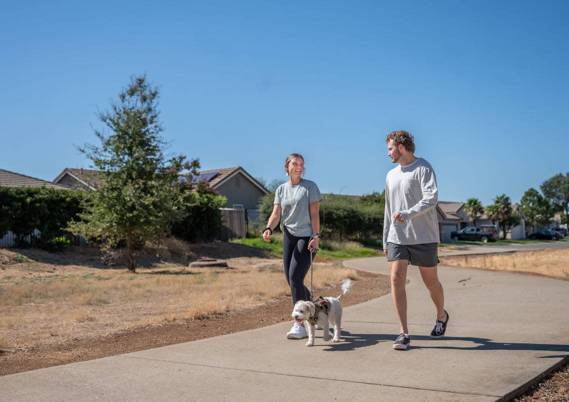 Olivia and Tanner Keller walk their dog Rory near their home in Lincoln on Tuesday, Oct. 3, 2023. Experts recommend taking pets out of exercised in the early morning or late evening when temperatures are lowest.