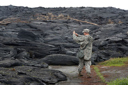 Tech Sgt. Andrew Lee Jackson, of the Hawaii National Guard, takes photos of the Kilauea lava flow, in Leilani Estates near Pahoa, Hawaii, U.S., May 29, 2018. REUTERS/Marco Garcia