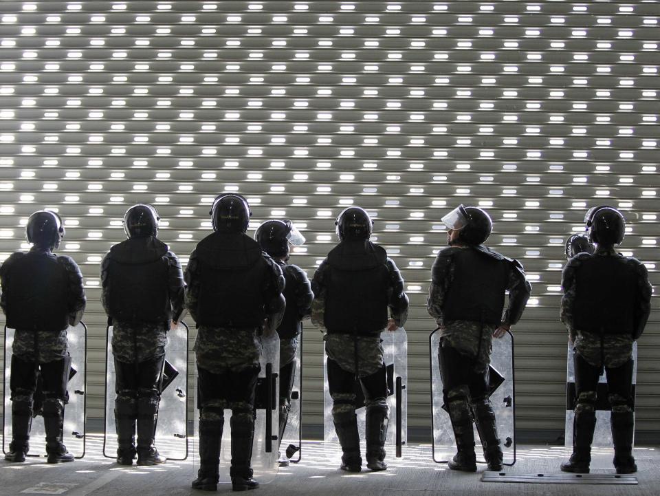 Soldiers stands guard at the temporary office of Thai Prime Minister Yingluck Shinawatra during a protest in Bangkok February 17, 2014. Hundreds of unpaid Thai rice farmers swarmed around the office on Monday, threatening to storm the building if the beleaguered premier did not come out and speak to them. The escalation of the protest by farmers, who have not been paid for crops sold to the government under a state rice-buying scheme that helped sweep Yingluck's Puea Thai Party to power, came as thousands of demonstrators seeking to unseat the prime minister surrounded the government's headquarters. . REUTERS/Chaiwat Subprasom (THAILAND - Tags: POLITICS CIVIL UNREST TPX IMAGES OF THE DAY)