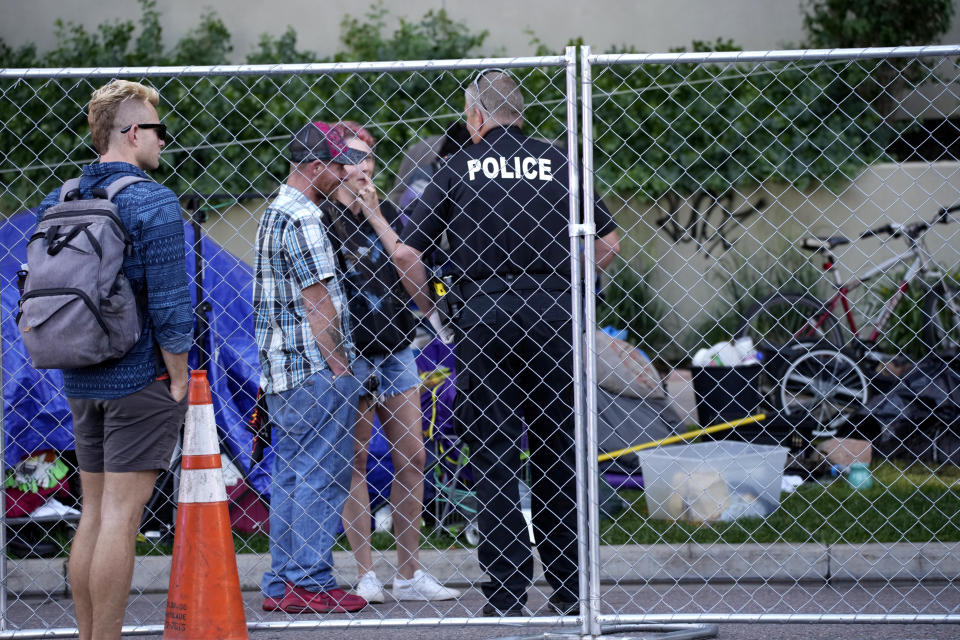 A city-sponsored sweep is carried out on an encampment of individuals living along Grant Street at Sixth Avenue south of downtown Denver on Wednesday, July 7, 2021. (AP Photo/David Zalubowski)