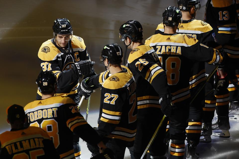 Boston Bruins' Patrice Bergeron (37) greets teammates during introductions before an NHL hockey game against the Arizona Coyotes, Saturday, Oct. 15, 2022, in Boston. (AP Photo/Michael Dwyer)