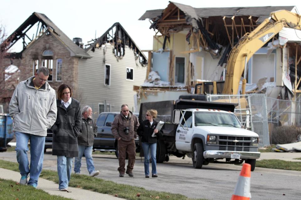 Brett, left, and his wife Nikki Cocherell walk away from the site where their home was being demolished in Indianapolis, Tuesday, Nov. 27, 2012. City building inspectors last week ordered the demolition of 29 houses by Dec. 20. Four other homes, including two that were leveled in the Nov. 10 explosion, are being maintained as police investigate what they believe was an intentional natural gas explosion. (AP Photo/Michael Conroy)