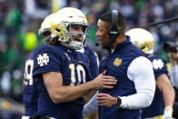 Notre Dame quarterback Sam Hartman (10) celebrates with head coach Marcus Freeman during the second half of an NCAA college football game against Pittsburgh Saturday, Oct. 28, 2023, in South Bend, Ind. (AP Photo/Michael Caterina)