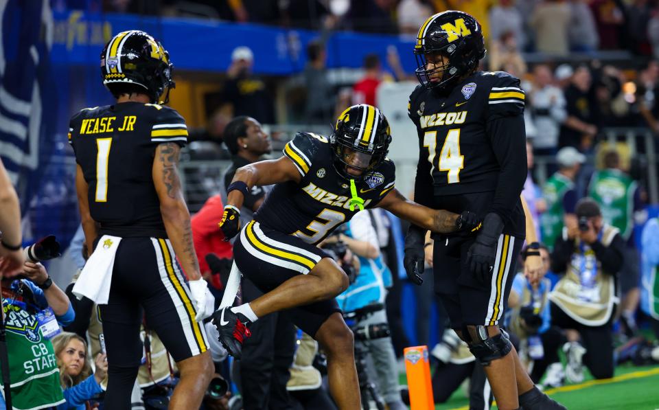 Missouri wide receiver Luther Burden III (3) celebrates with teammates Theo Wease Jr. (1) and Cam'Ron Johnson (74) after catching a touchdown pass during the 2023 Cotton Bowl at the AT&T Stadium.
