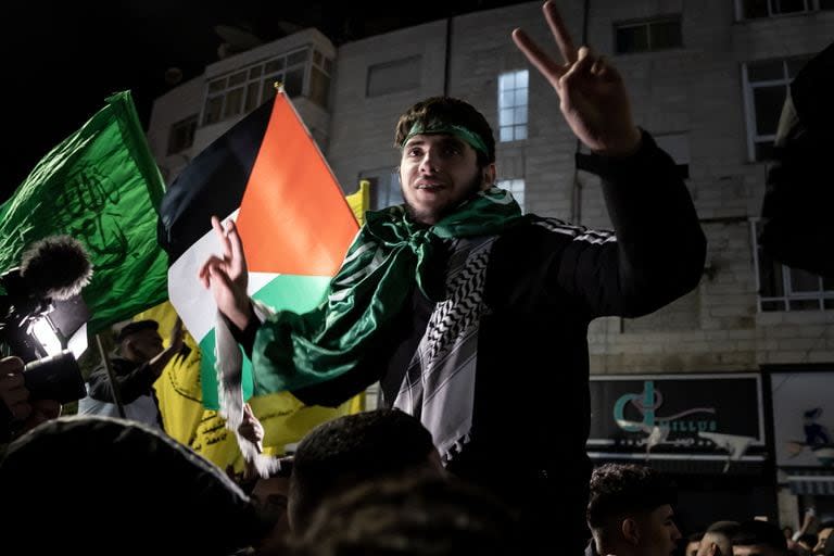 Un preso palestino gesticula mientras la multitud da la bienvenida a los presos liberados de las cárceles israelíes a cambio de los rehenes israelíes liberados por Hamás de la Franja de Gaza, en Ramala, en la Cisjordania ocupada, el 26 de noviembre de 2023.