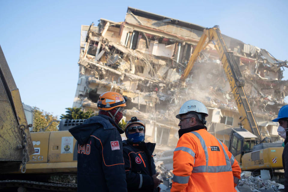 <div class="inline-image__caption"><p>Three rescue workers in discussion outside a building being demolished in Antakya.</p></div> <div class="inline-image__credit">Tom Mutch</div>