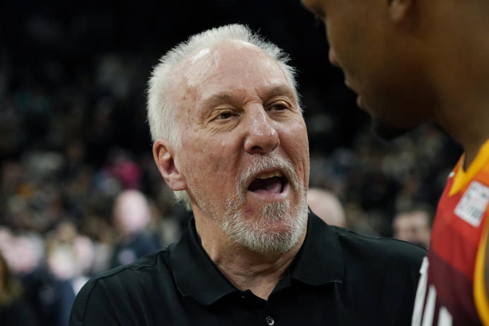 San Antonio Spurs head coach Gregg Popovich, left, is greeted by Utah Jazz forward Rudy Gay following their NBA basketball game, Friday, March 11, 2022, in San Antonio. The Spurs won, making Popovich the all-time winningest coach in NBA regular-season history. (AP Photo/Eric Gay)