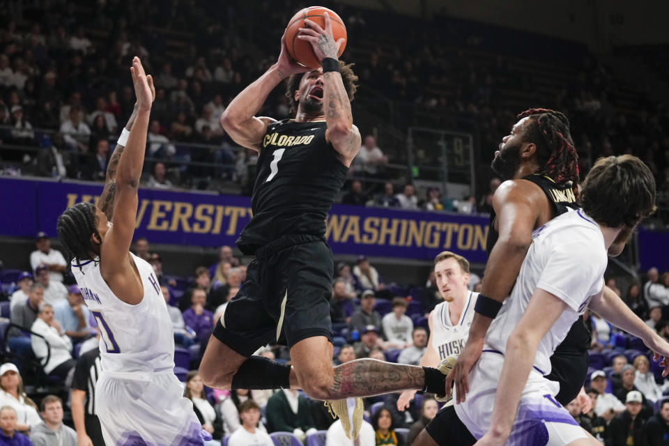 Colorado guard J'Vonne Hadley (1) shoots from between Washington guard Koren Johnson (0) and Colorado center Eddie Lampkin Jr., second from right, during the second half of an NCAA college basketball game Wednesday, Jan. 24, 2024, in Seattle. Colorado won 98-81. (AP Photo/Lindsey Wasson)