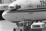 FILE - In this Wednesday, June 19, 1985 file photo, a hijacker points a weapon toward an ABC news media crew from the window of the cockpit of the Trans World Airlines jet as the American television crew approaches the jet for an interview at Beirut International Airport, Lebanon. Greek police said Saturday Sept. 21, 2019, they have arrested a suspect in the 1985 hijacking of a flight from Athens that included the slaying of an American. (AP Photo/Herve Merliac, File)