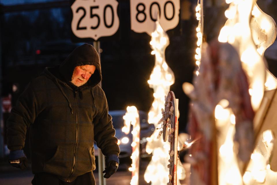 Greg Puntenney checks over electrical connections of Christmas display located at the corner of Commercial Avenue and South Broadway Street in New Philadelphia.