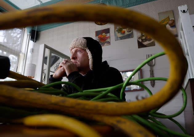Tom Markey, an employee at Betsy's Crepes in Southern Pines, North Carolina, sits next to power cords supplying a generator inside the restaurant on Dec. 5.