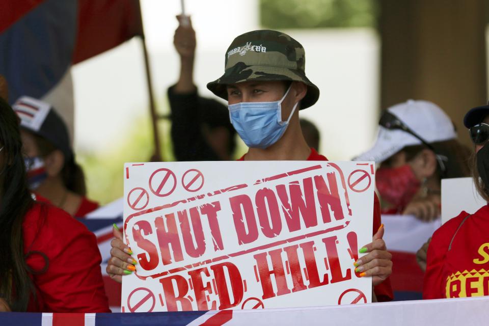 People hold signs in front of the Hawaii state Capitol during a rally calling for the closure of the Navy's Red Hill underground fuel storage facility near Pearl Harbor, Friday, Feb. 11, 2022 in Honolulu.