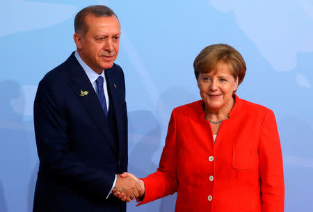 Turkish President Recep Tayyip Erdogan shakes hands with German Chancellor Angela Merkel as he arrives for the G20 leaders summit in Hamburg, Germany July 7, 2017. REUTERS/Kai Pfaffenbach/File Photo