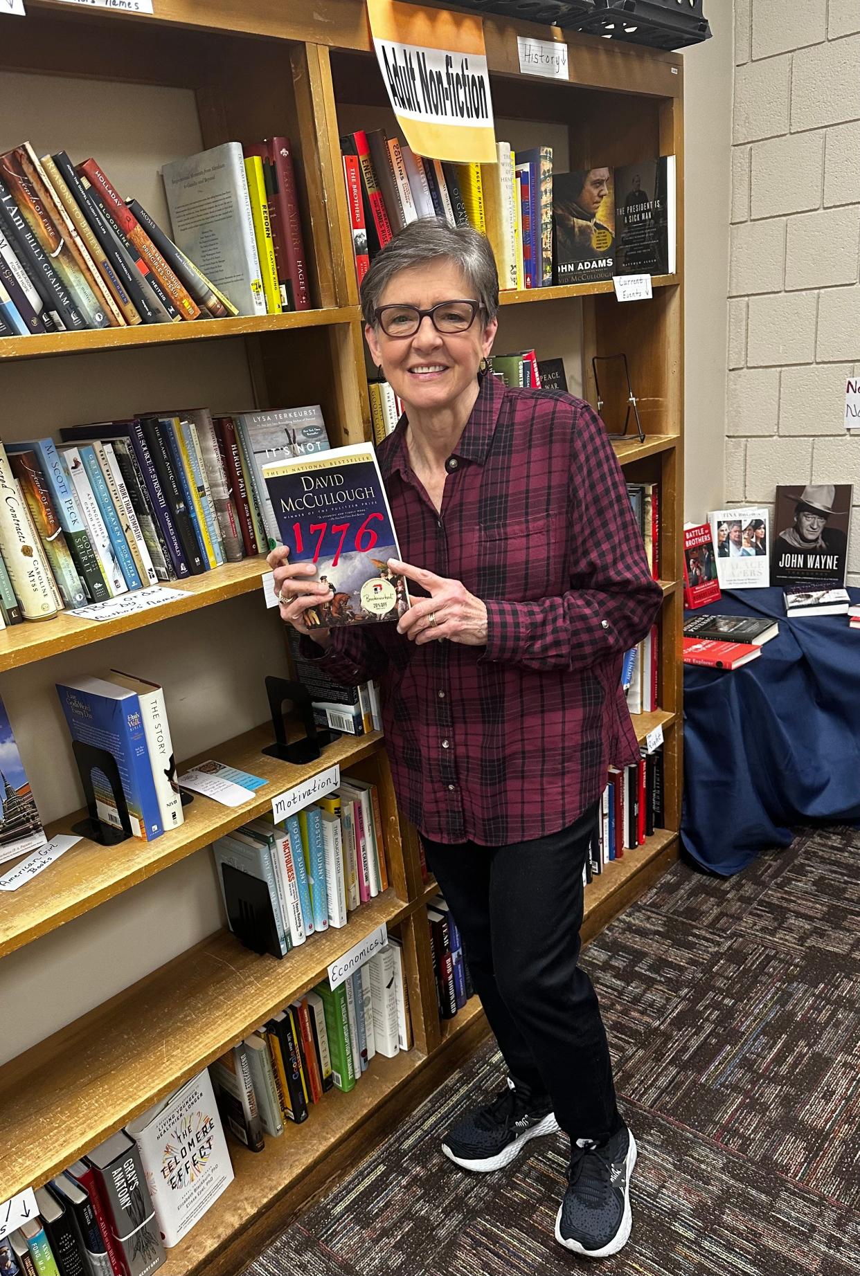 Jann Ford, president of the Friends of the Cleveland County Library System, holds up one of the books available at the pop-up book sale.